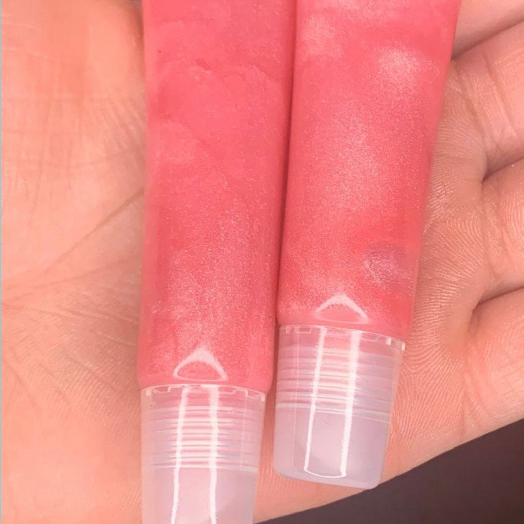 Lip gloss tubes with pink gloss, clear plastic tube, and a shiny finish.