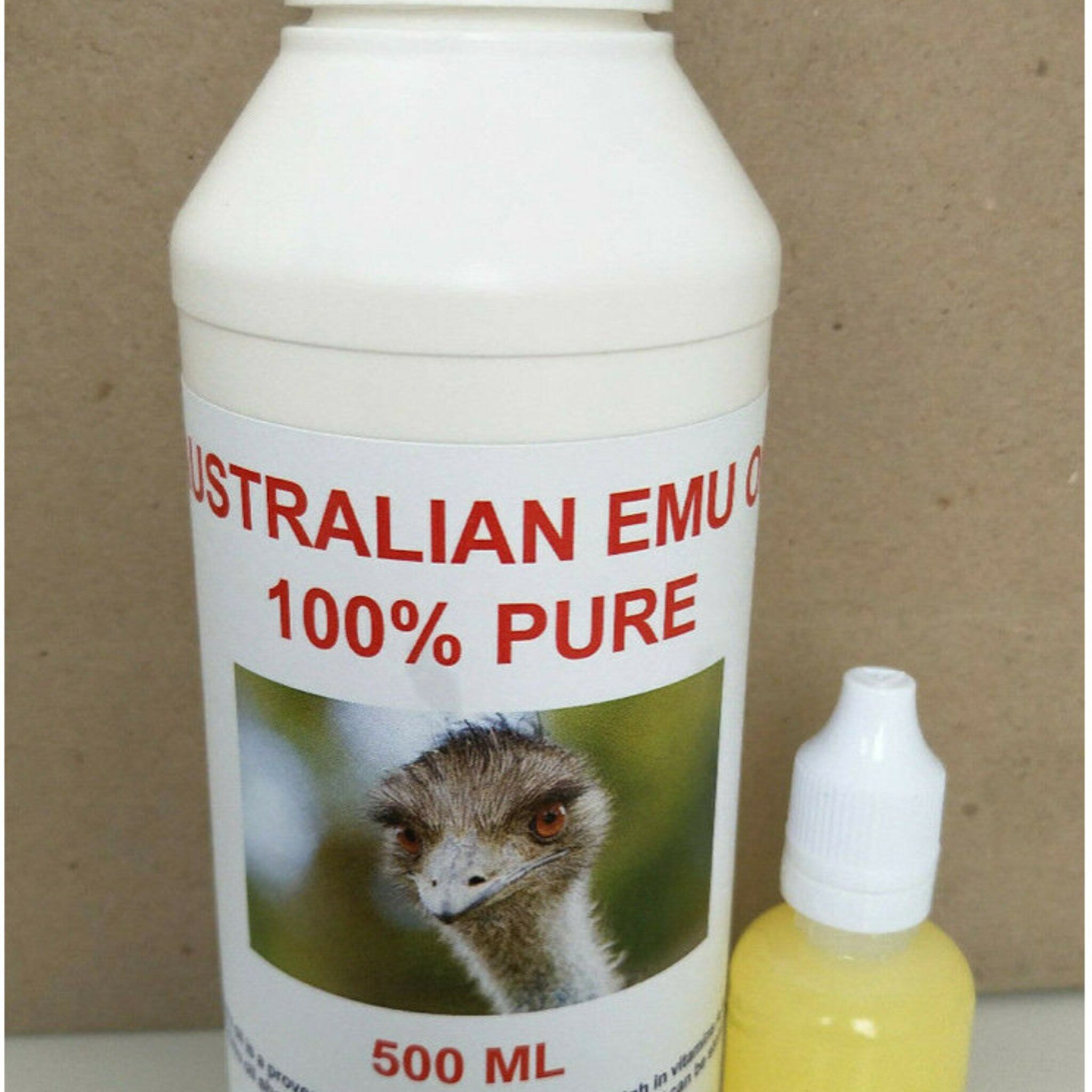 Amber glass bottle of 100% pure emu oil with gold-toned dropper and minimalist label