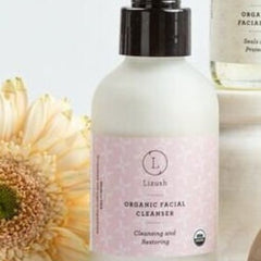 Organic facial cleanser bottle with pink label, white bottle, and black pump top, Lizush brand