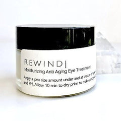 Eye cream glass jar with black lid and REWIND label, skincare product
