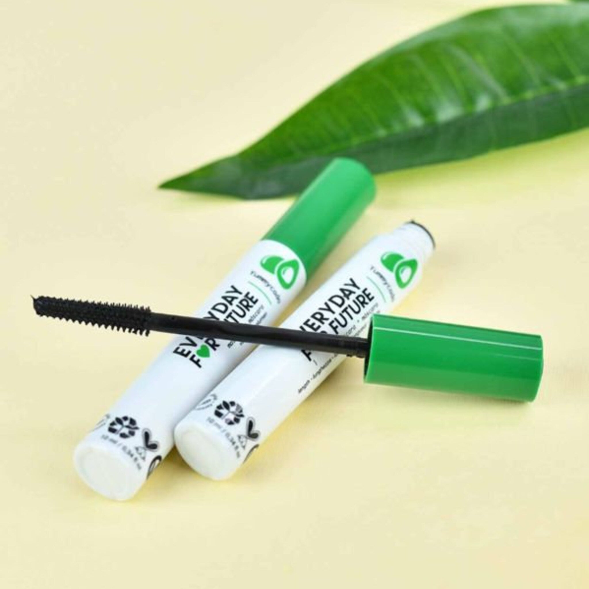 Mascara tubes with green caps and white tubes, black brush applicator, "Everyday Future" text