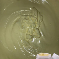Creamy yellow cream with white and yellow swirls, in a jar and spread out