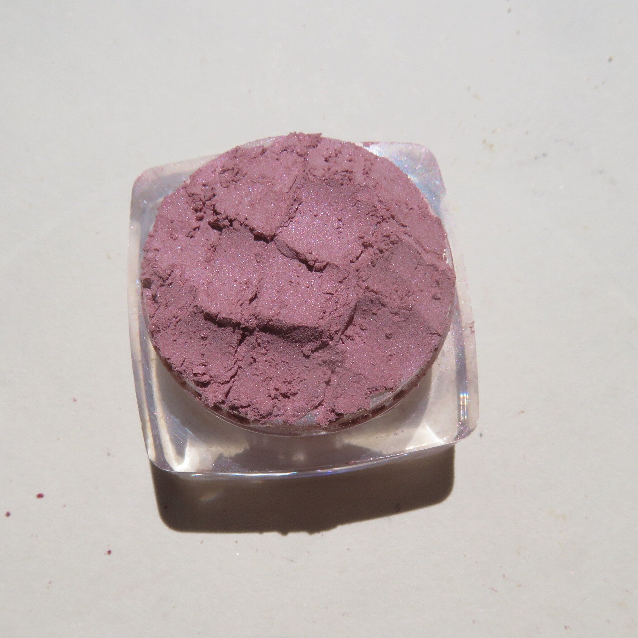 Open compact showcasing loose pale mauve mineral eyeshadow with vegan label visible