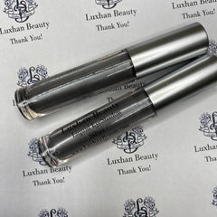 Hand applying shimmery silver liquid eyeshadow with glitter, creating a bold metallic statement on eyelid
