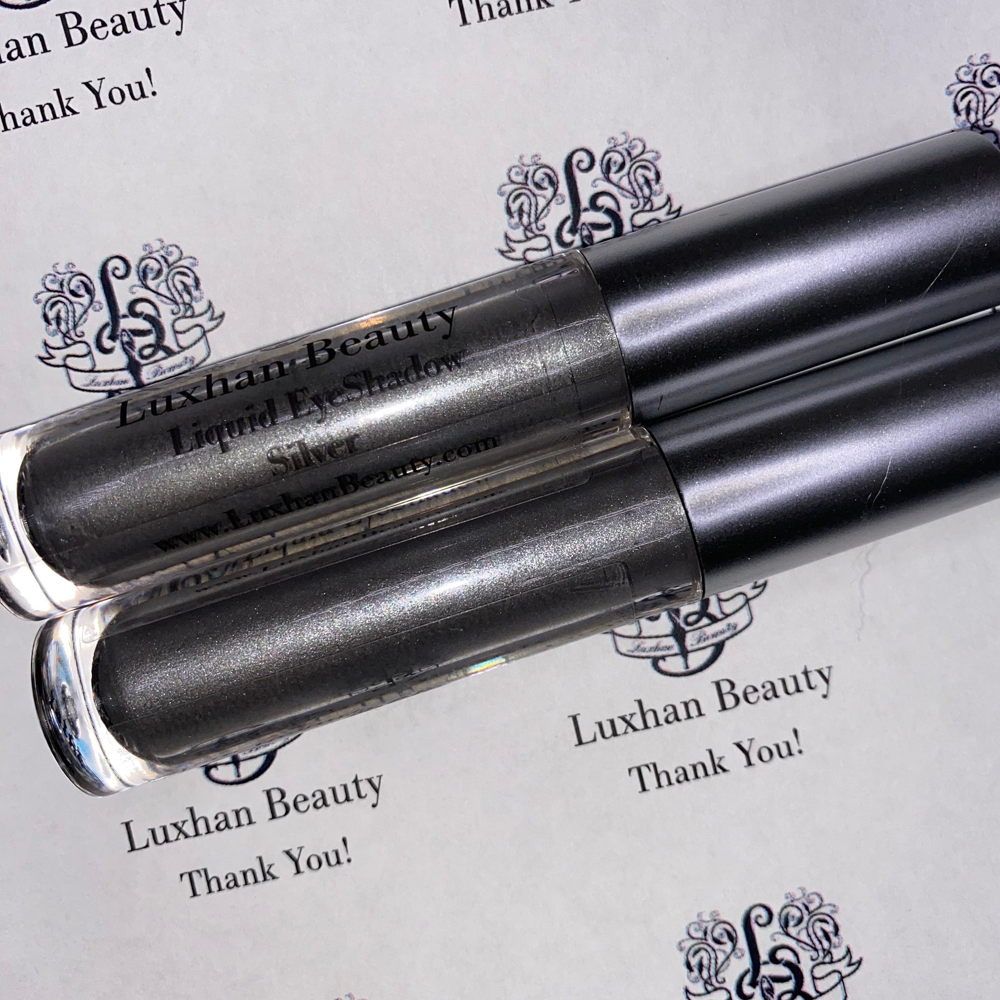 Close-up of silver glitter liquid eyeshadow shimmering with metallic finish in sleek tube packaging