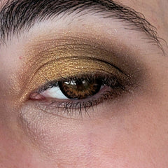 Close-up of espresso brown eye shadow being applied to eyelid with a fluffy blending brush