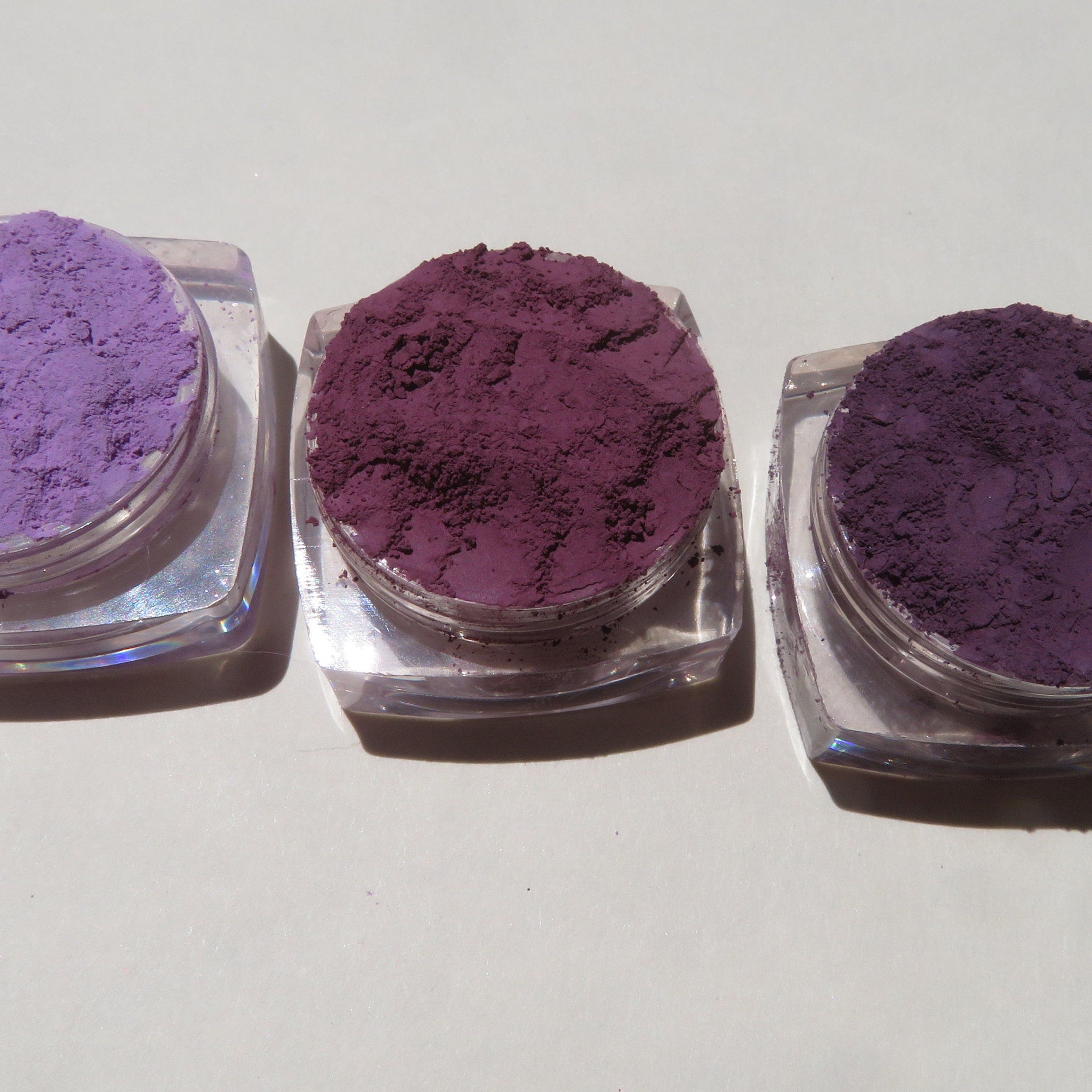 Close-up of matte purple loose mineral eyeshadow powder with vegan, cruelty-free label visible