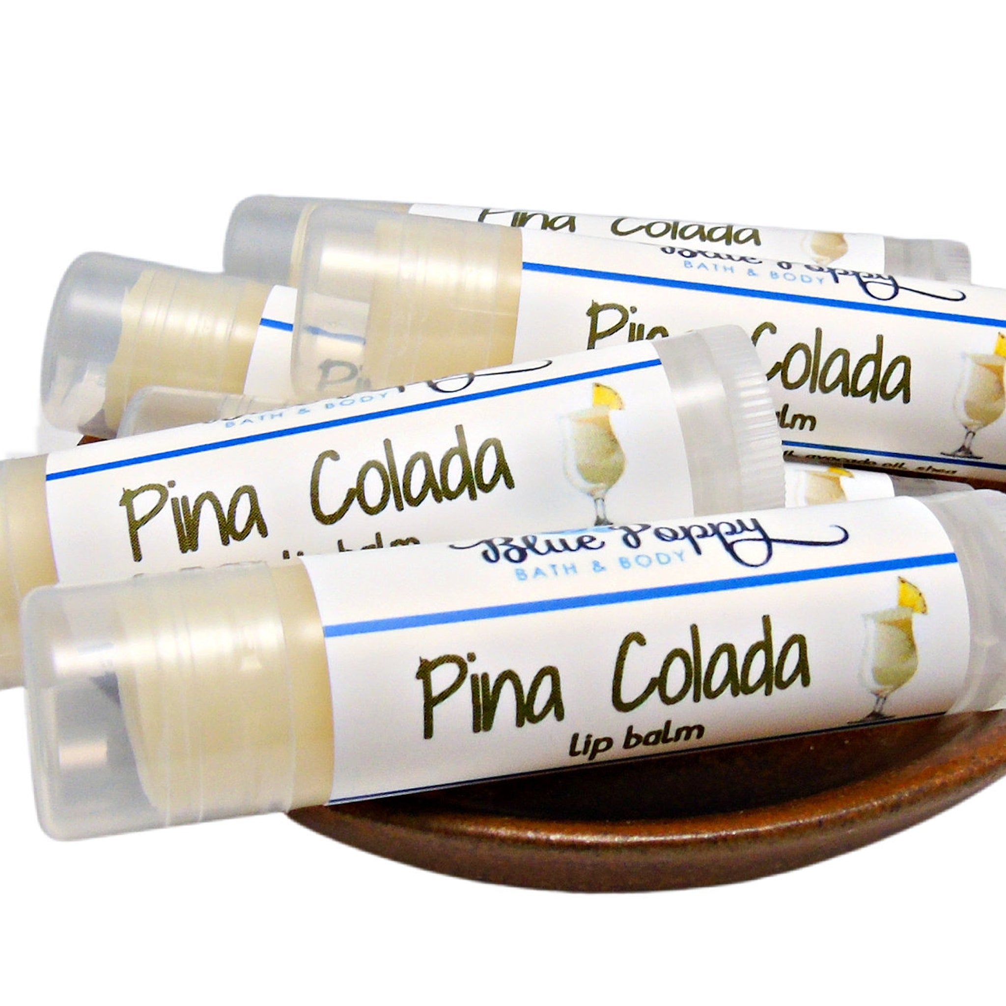 Lip balm tubes with white labels, clear caps, and "Pina Colada" text, Blue Poppy brand visible