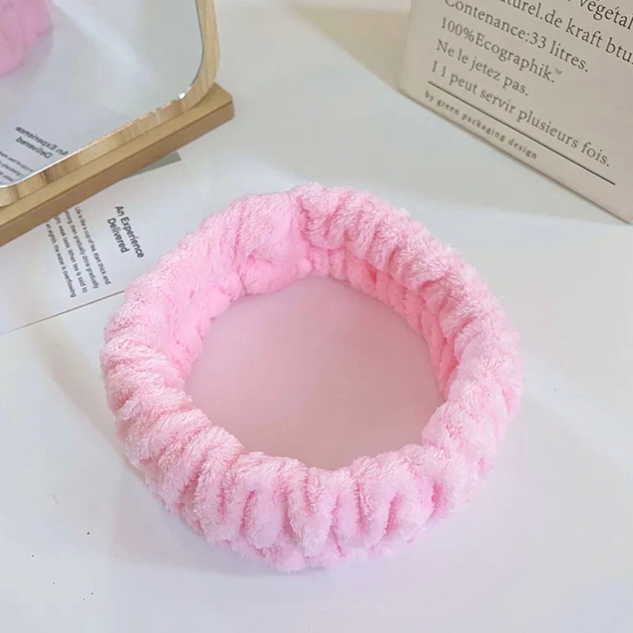 Pink terry cloth headband with soft texture, for skincare or beauty routine use