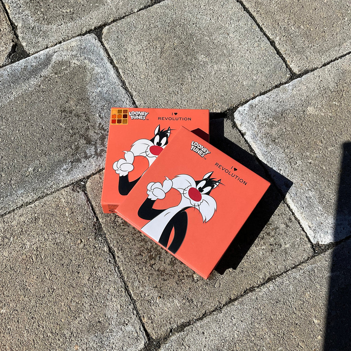 Front view of I Heart Revolution Sylvester Looney Tunes eyeshadow palette featuring colorful rectangular pans in vibrant shades