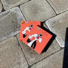 Front view of I Heart Revolution Sylvester Looney Tunes eyeshadow palette featuring colorful rectangular pans in vibrant shades