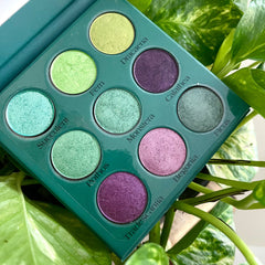 Side view of botanical eyeshadow palette showing 12 earthy green and pink shades in rectangular pans with floral design
