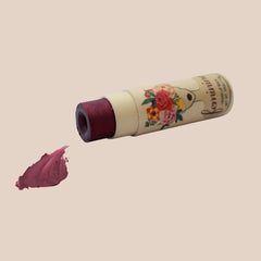 Lip balm in maroon color with floral design on a beige tube, Feminine brand visible