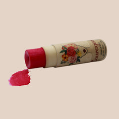 Lip balm with red color, floral print packaging, and "Courageous" text visible on tube