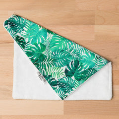White and green leaf print cloth with Little Miss M Designs tag, on wooden surface