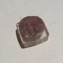 Side view of vegan loose powder eye shadow in dark brown matte finish with mineral texture