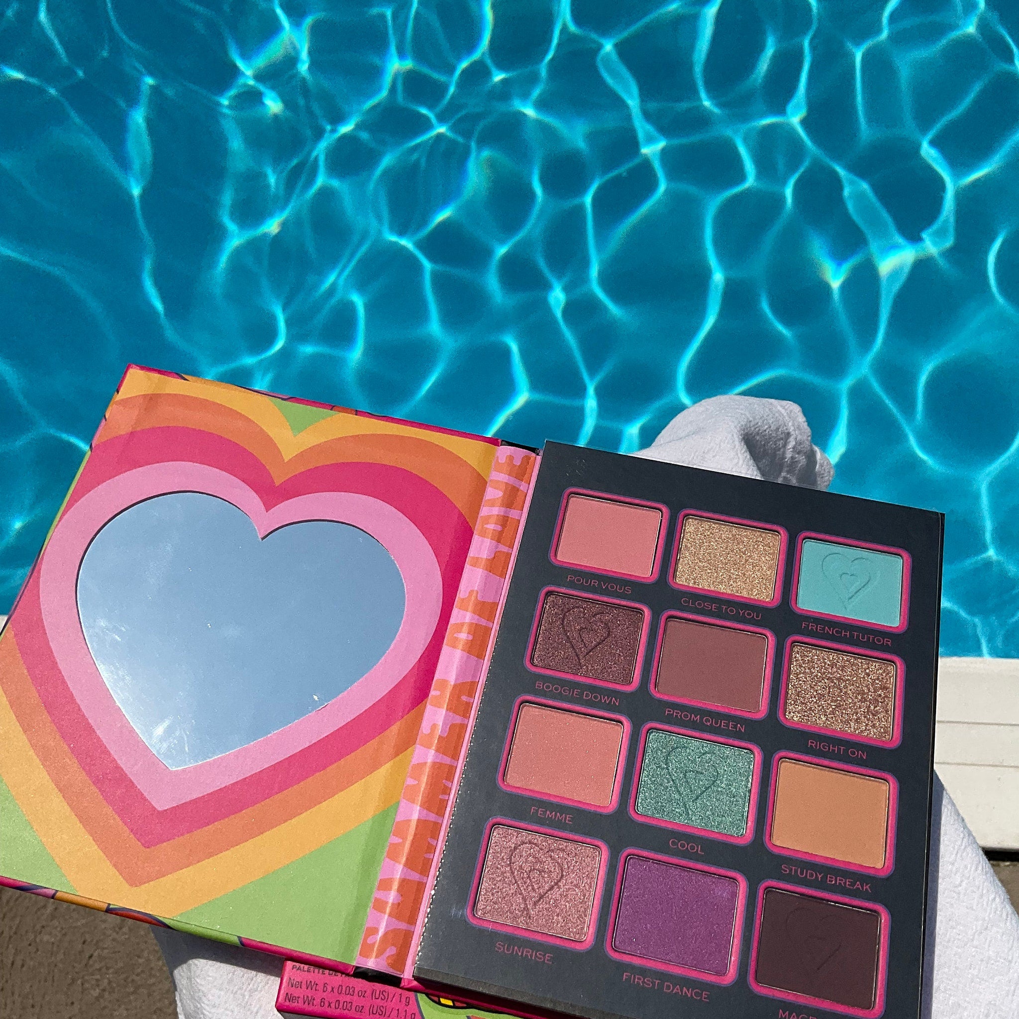 Eyeshadow palette with rainbow heart design, multiple colors, and mirror detail