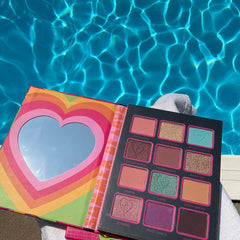 Eyeshadow palette with rainbow heart design, multiple colors, and mirror detail