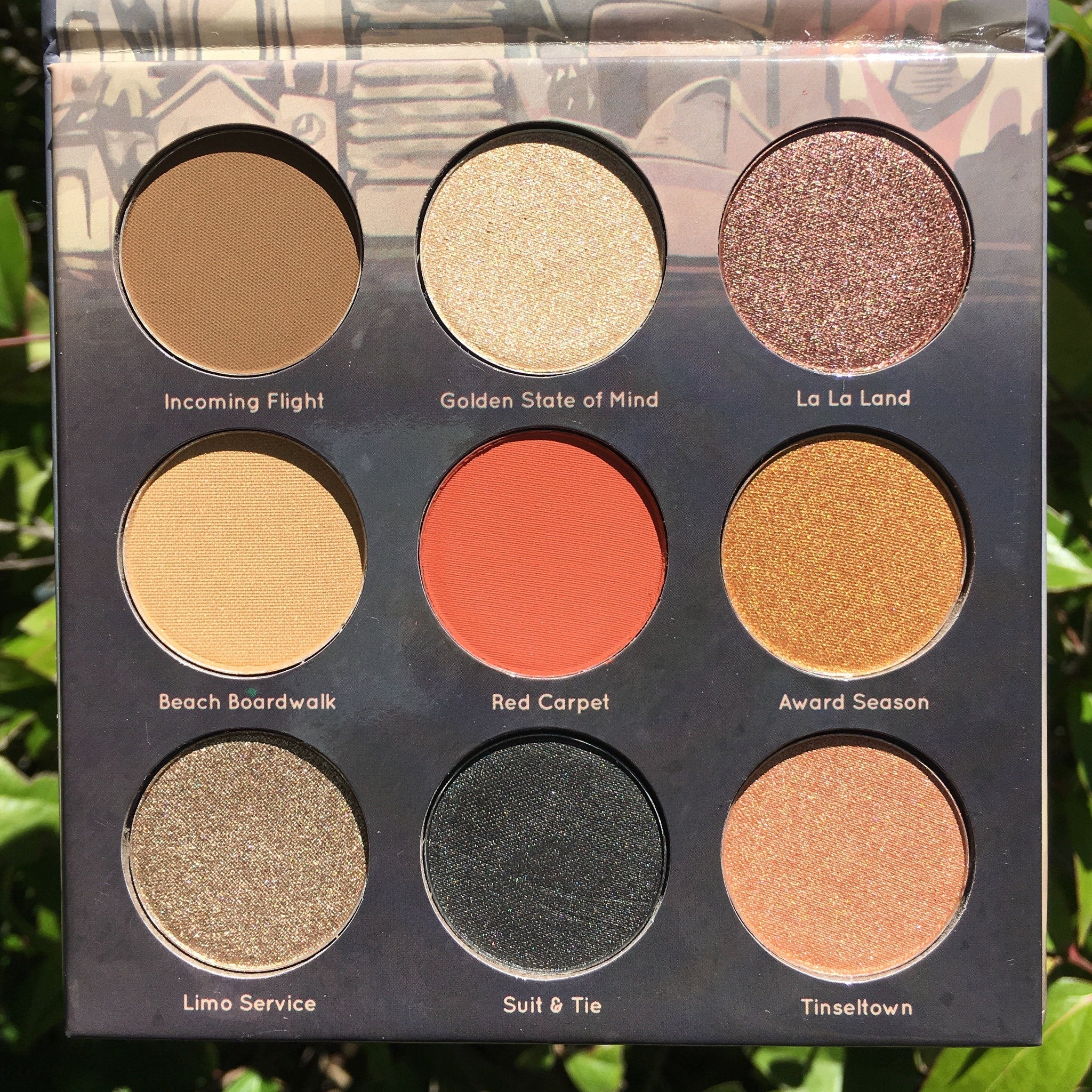 Eyeshadow palette with brown, gold, and red shades, Mavie. Cosmetics brand