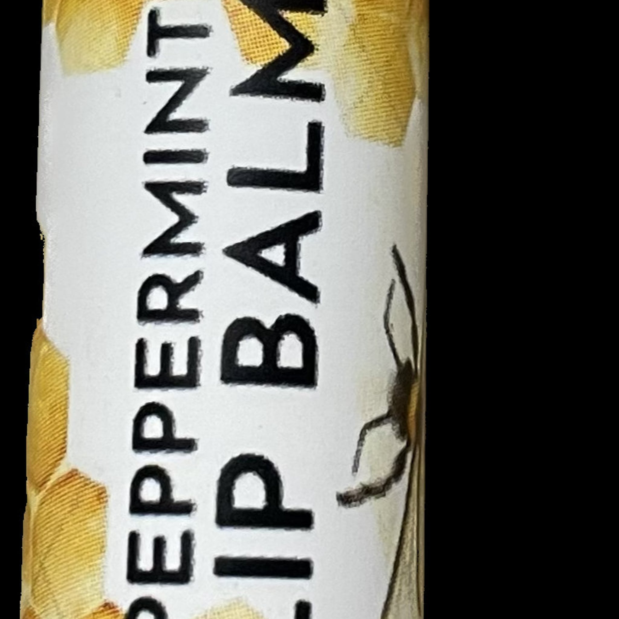 Lip balm tube with white label, black text, and yellow honeycomb pattern detail