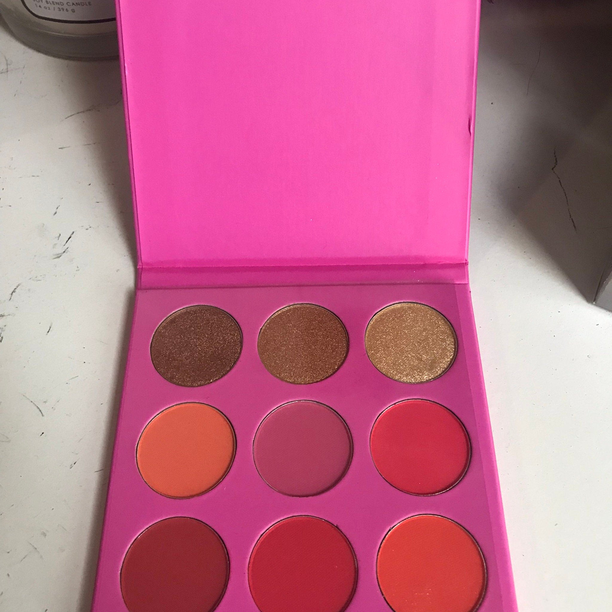 Close-up of Blatant Beauty Cupcake Eyeshadow Palette showing six vibrant matte and shimmer shades in pink, purple, and bronze tones