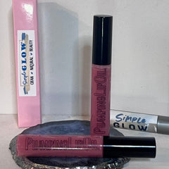 Lip oil with pink tint, black cap, and Simple Glow branding on packaging