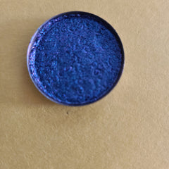 Close-up of Galaxia multichrome eyeshadow pan showing vibrant blue, purple, teal, and pink shimmer shift