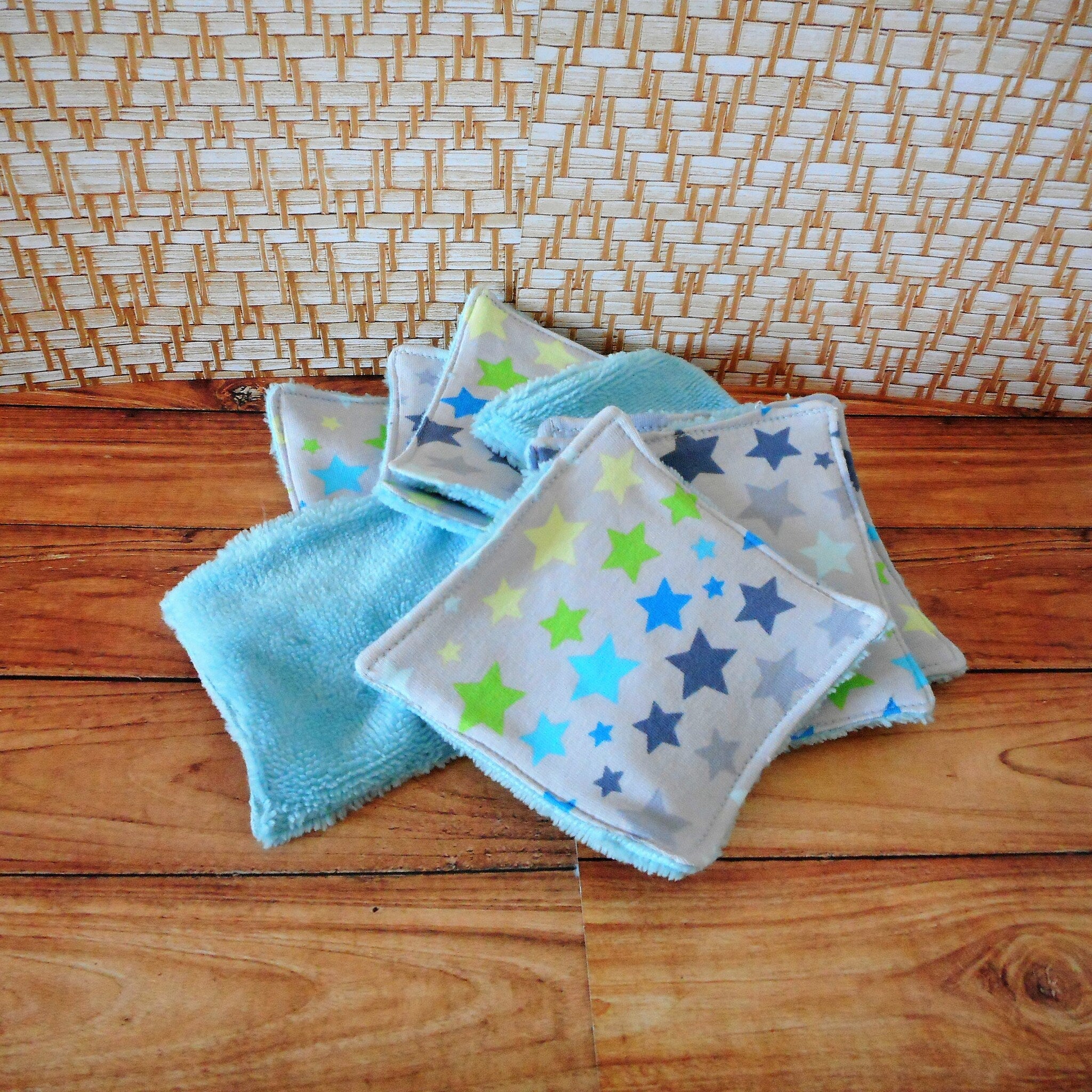 Washcloths with blue, green, and gray star pattern on white fabric, with a blue terrycloth texture