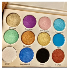 Close-up of vegan shimmer eyeshadow palette showing iridescent pink and gold shades with crystal sparkle
