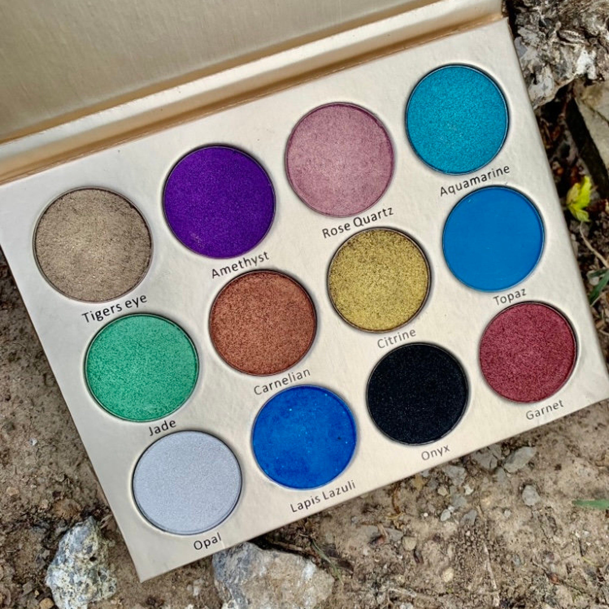 Close-up of shimmering teal and violet eyeshadows in Painted Fairy palette showing sparkling crystal texture