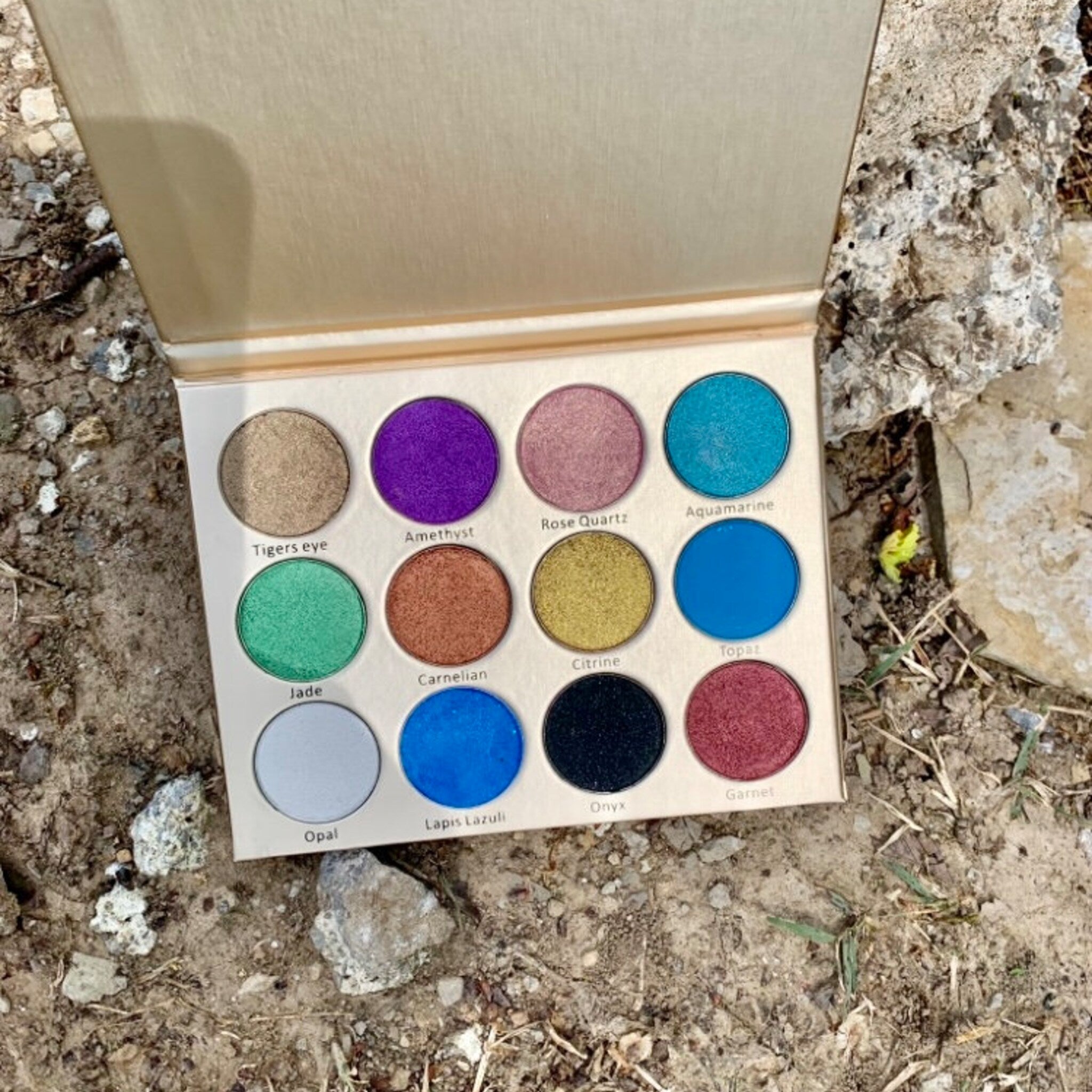 Painted Fairy Crystal Eyes palette open with 12 shimmer shades arranged in two rows, showcasing vegan eye shadows.
