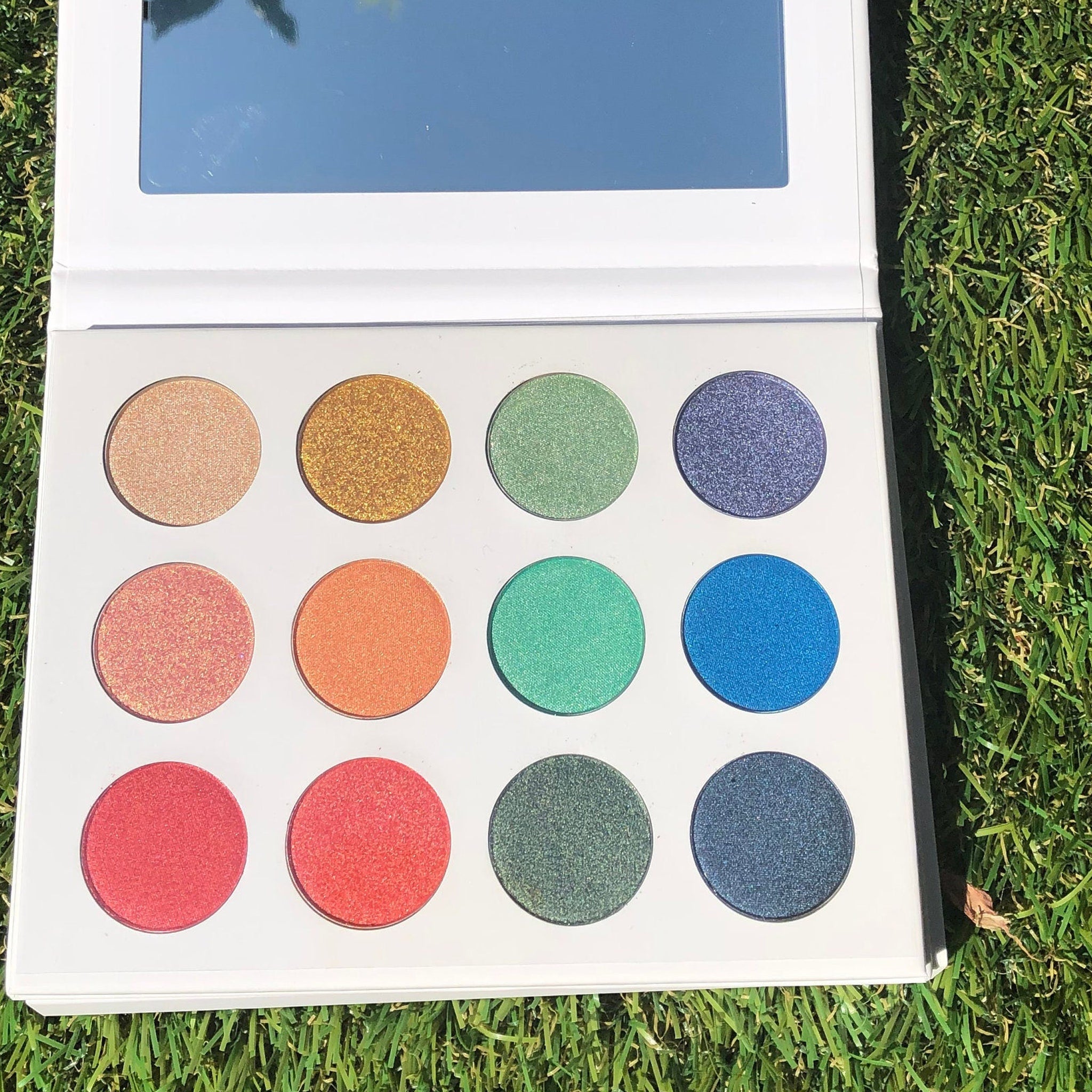 Side view of Fairy Dust Palette showing six shimmering eye shadow shades in a sleek black compact