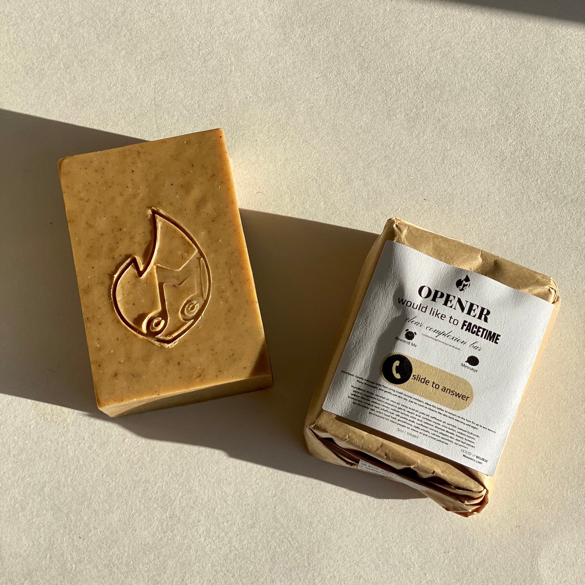 Soap bar with logo, brown color, packaged with "OPENER" label, on white surface
