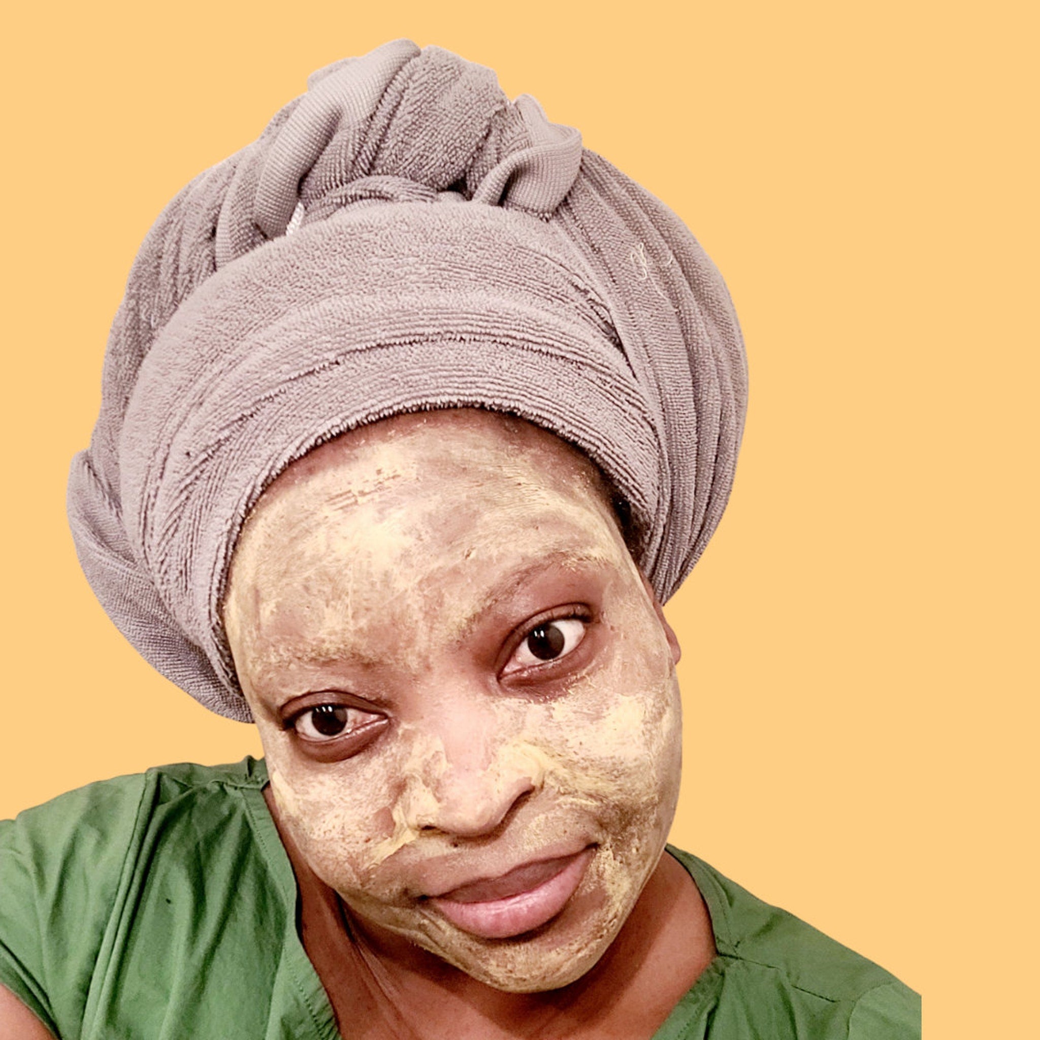 Close-up of golden turmeric clay mask in jar with natural texture and visible herbal flecks