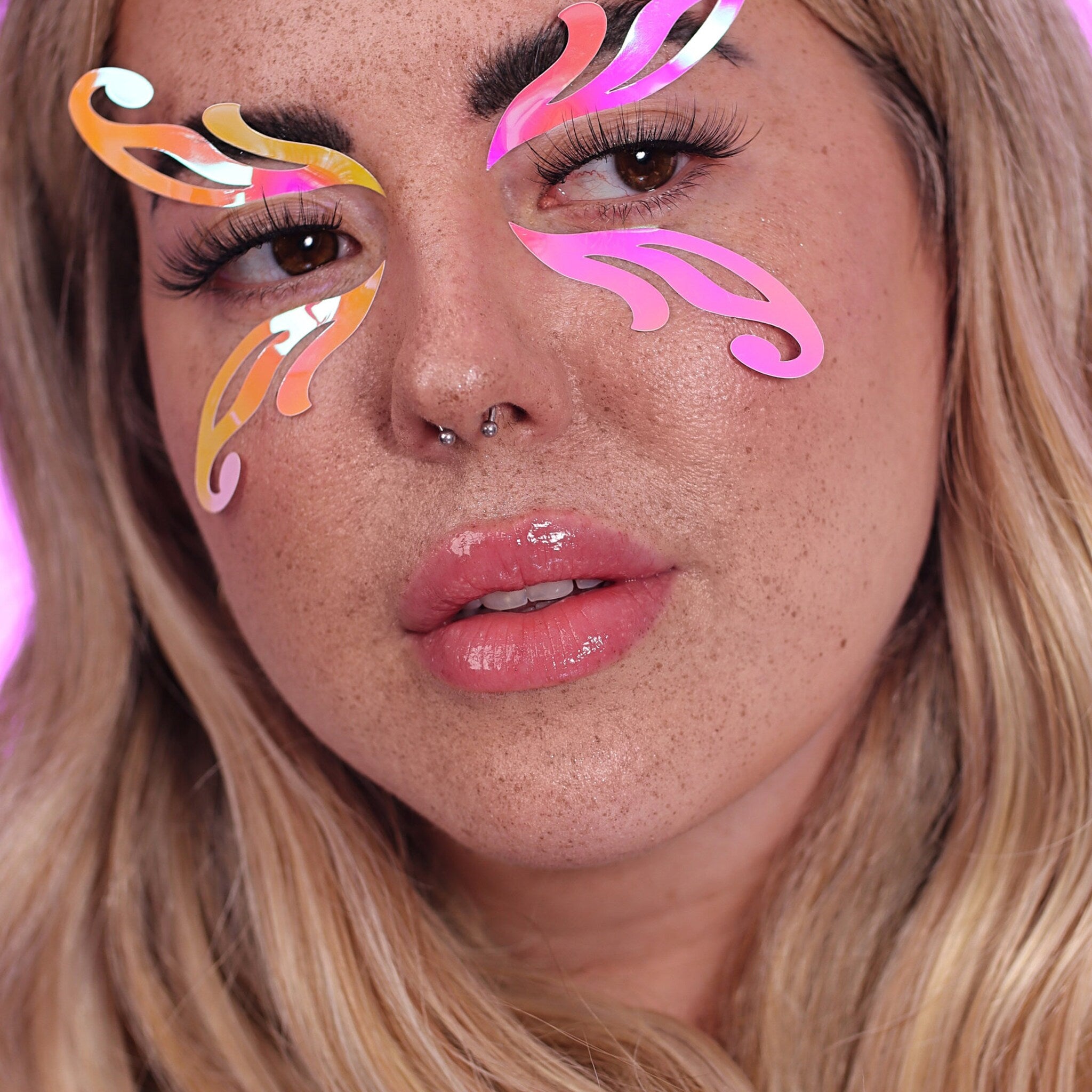 Eye makeup stickers with iridescent color and curved shape on face of person
