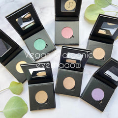 Close-up of fingertips applying black mineral eyeshadow with smoky finish to eyelid crease