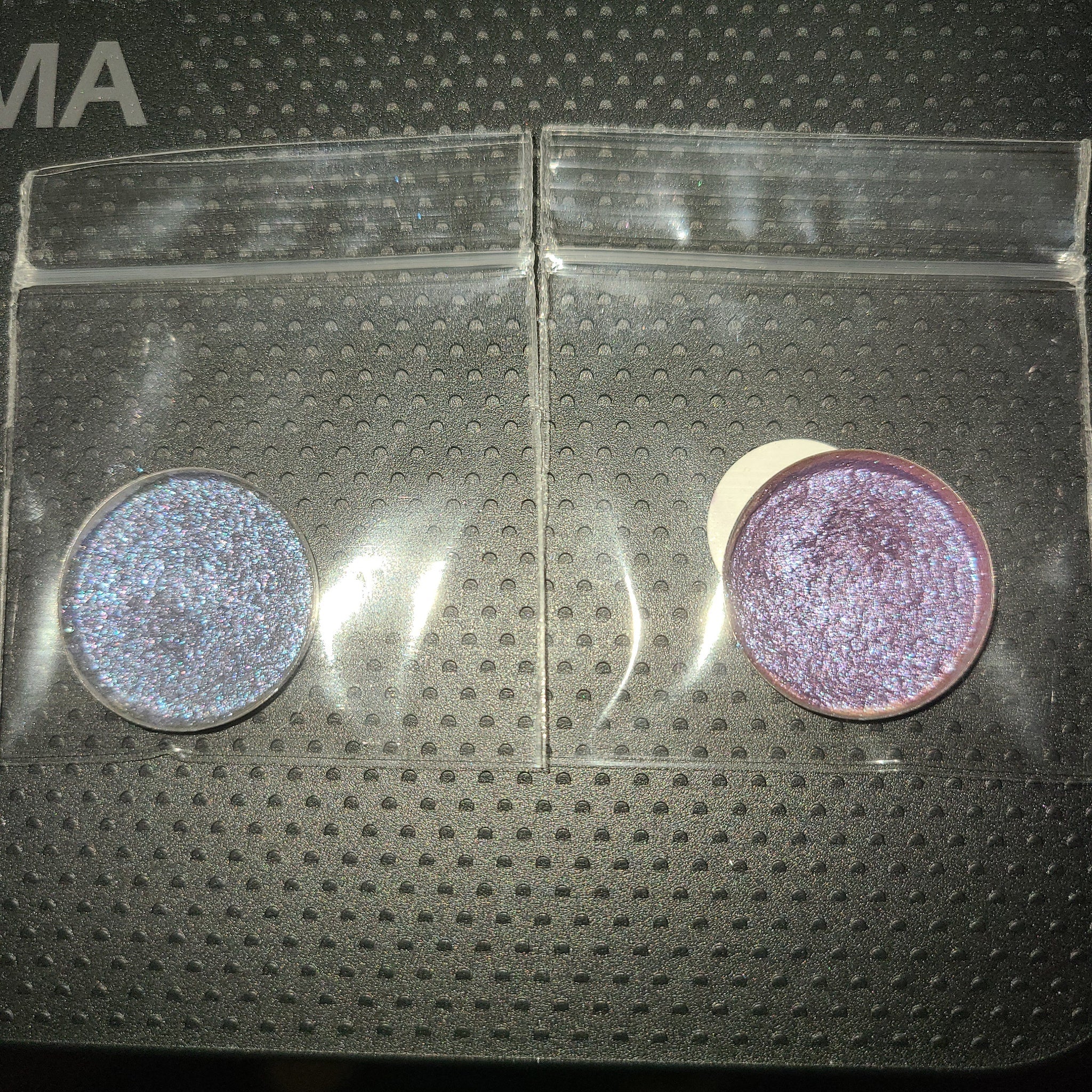 Two-tone purple eye shadow palette with deep plum and soft lilac shades in sleek compact packaging