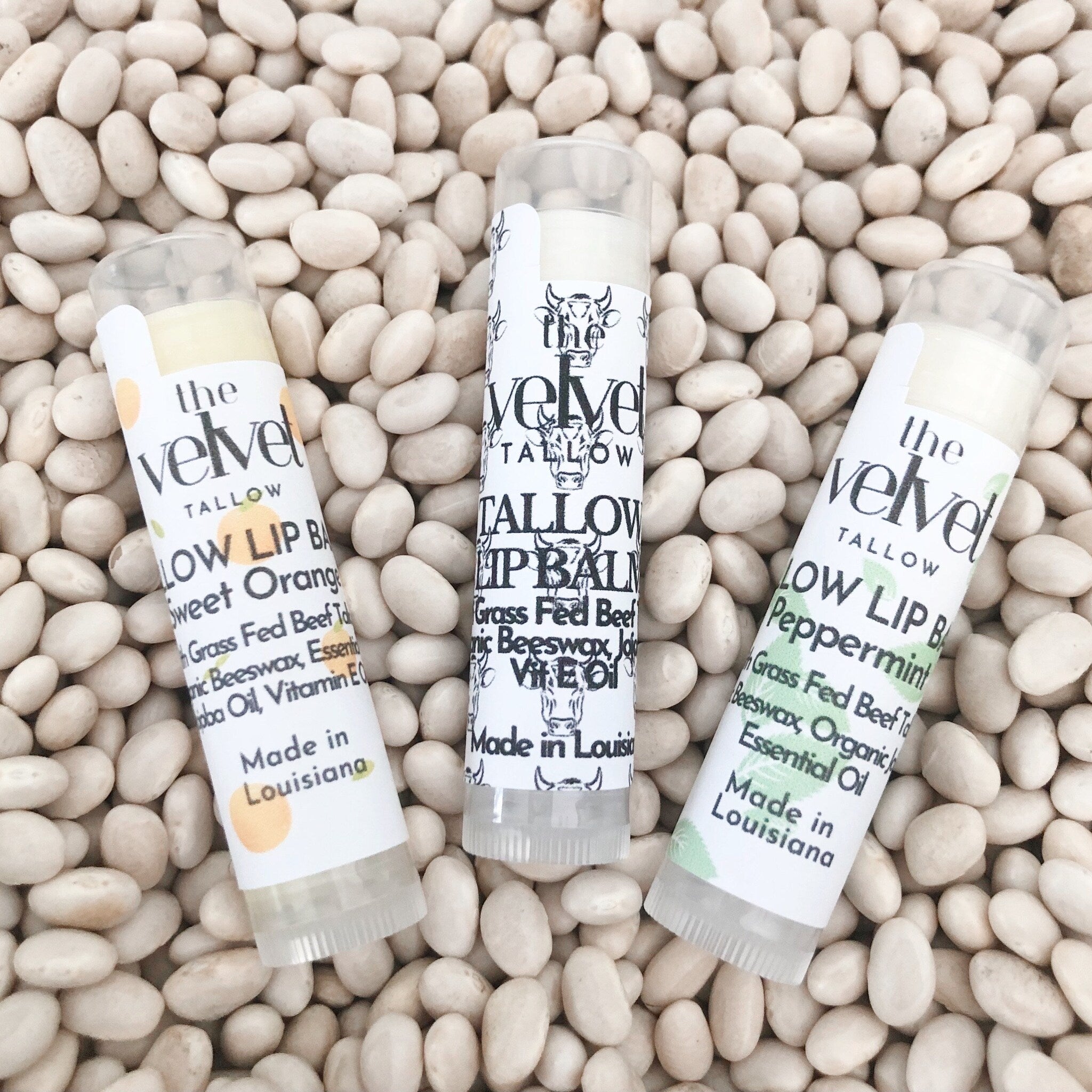 Lip balm tubes with white labels, clear tubes, and text on white beans