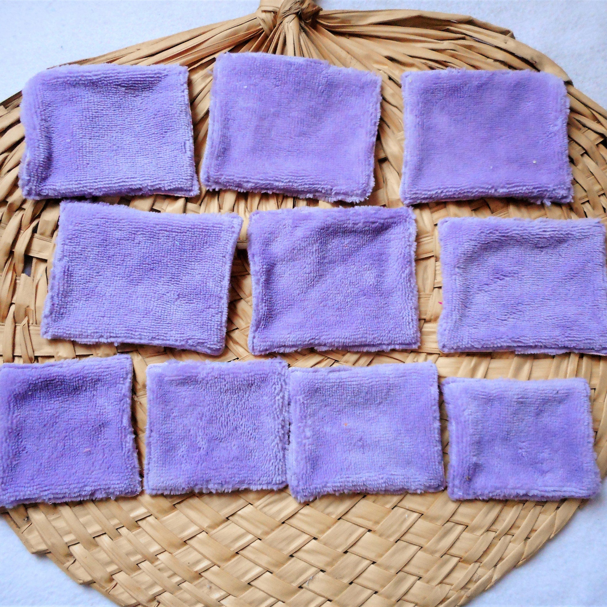Purple square microfiber cloths on woven straw background