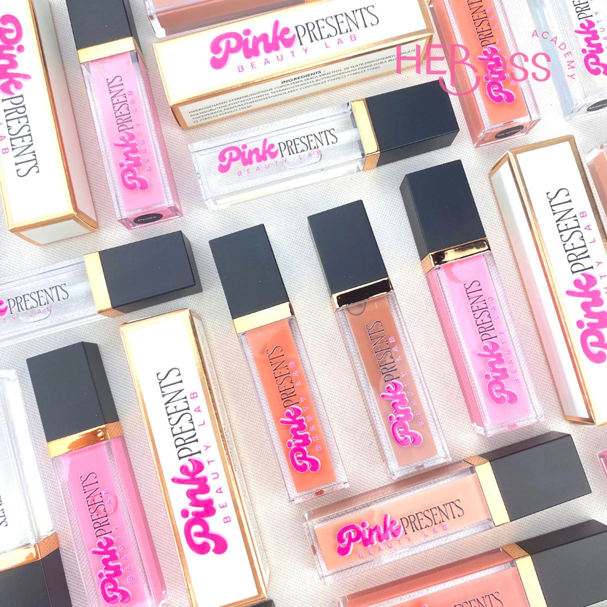 Lip gloss tubes in pink, peach, and clear with black and gold caps, Pink Presents brand