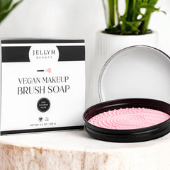 White vegan makeup brush soap bar with free green scrubber on bamboo tray