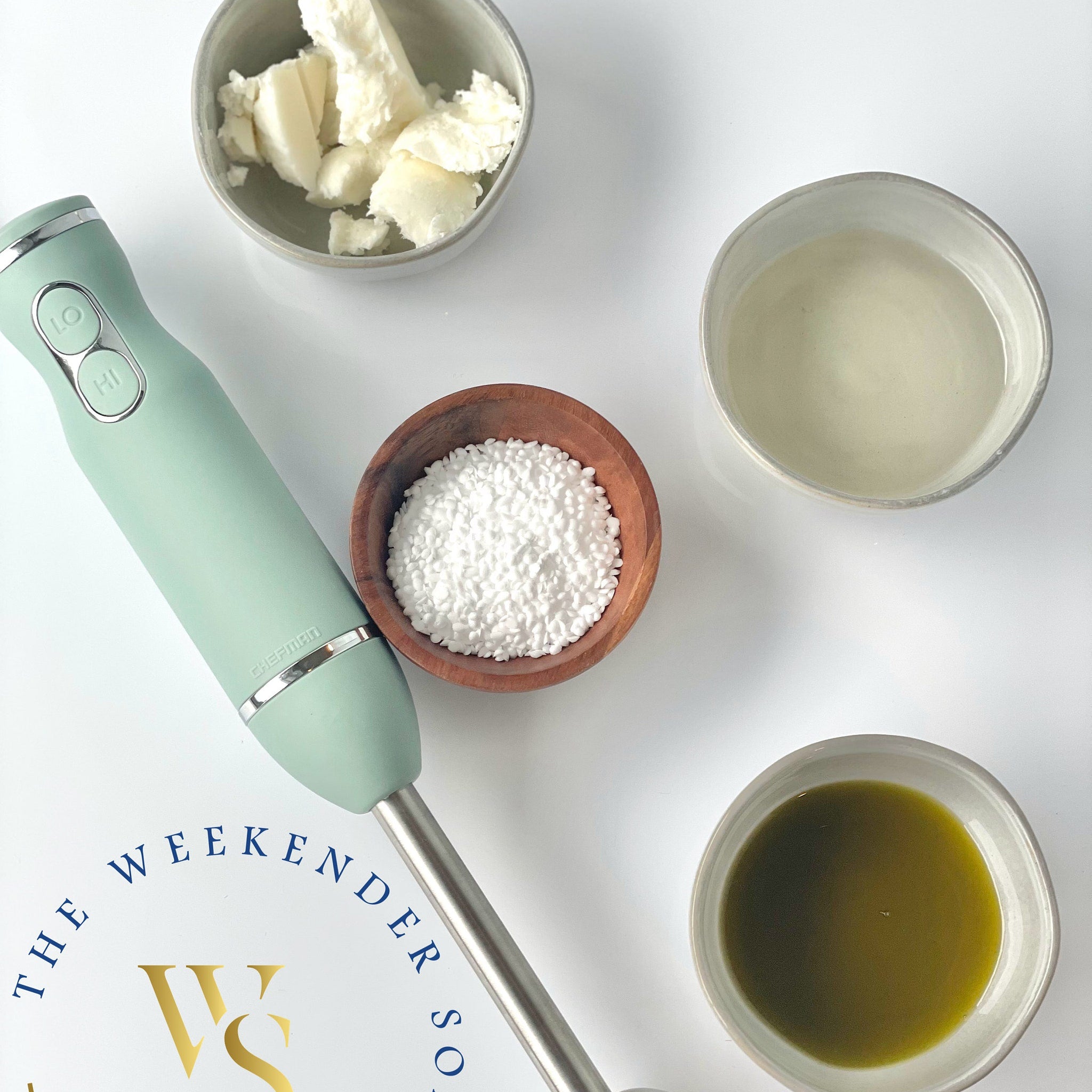 Mint green hand blender with silver accents and ingredients for soap making, CHEFMAN brand visible