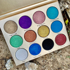 Side view of Painted Fairy eyeshadow palette showing six shimmer shades in pink, gold, and bronze hues with crystal-inspired packaging