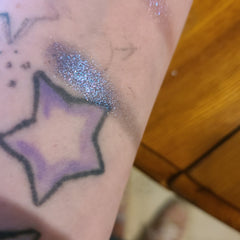 Close-up of two purple eyeshadow pans showing bruised plum and soft lavender shades with smooth satin finish