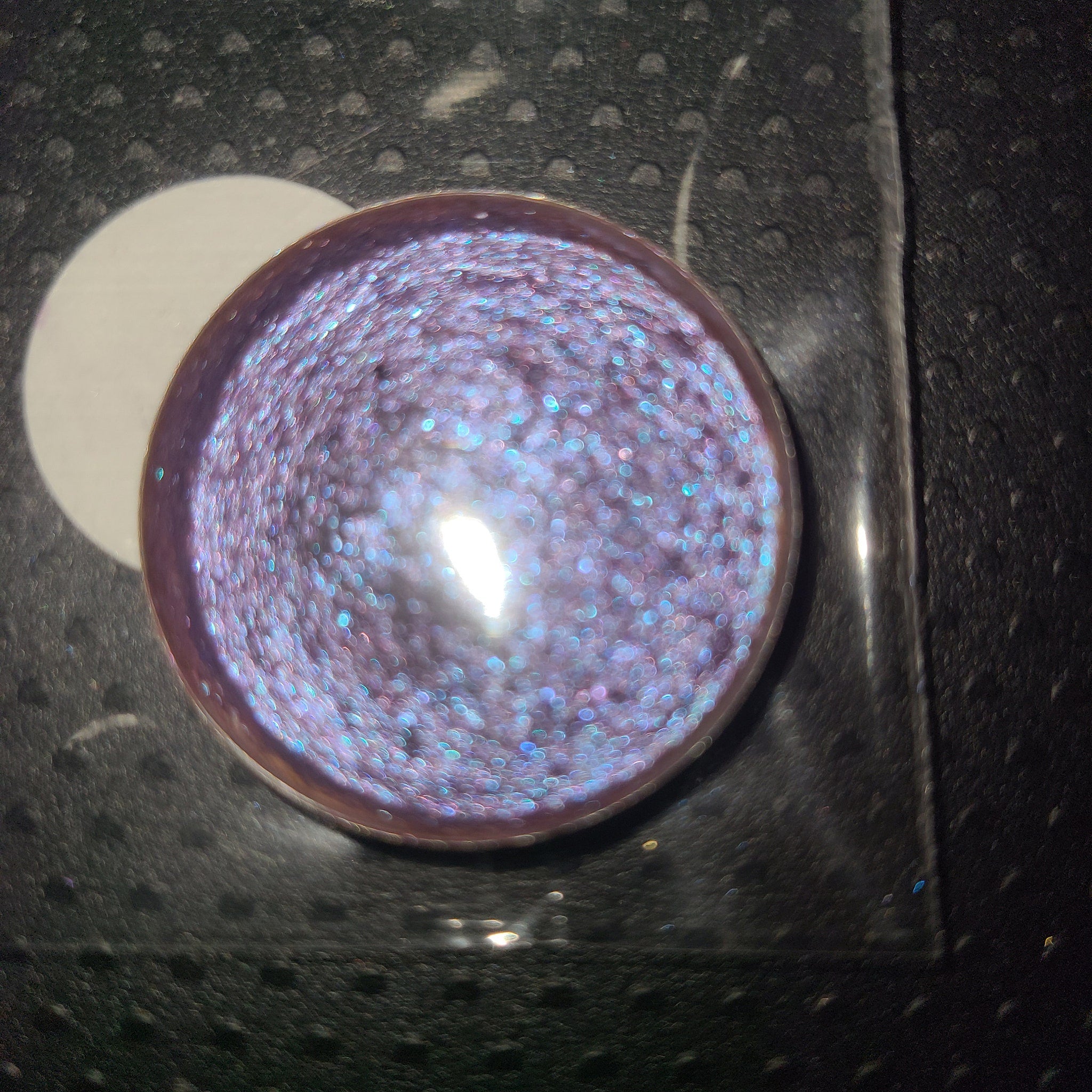 Side view of two purple eyeshadow pans showing gradient from deep plum to soft lavender in compact case