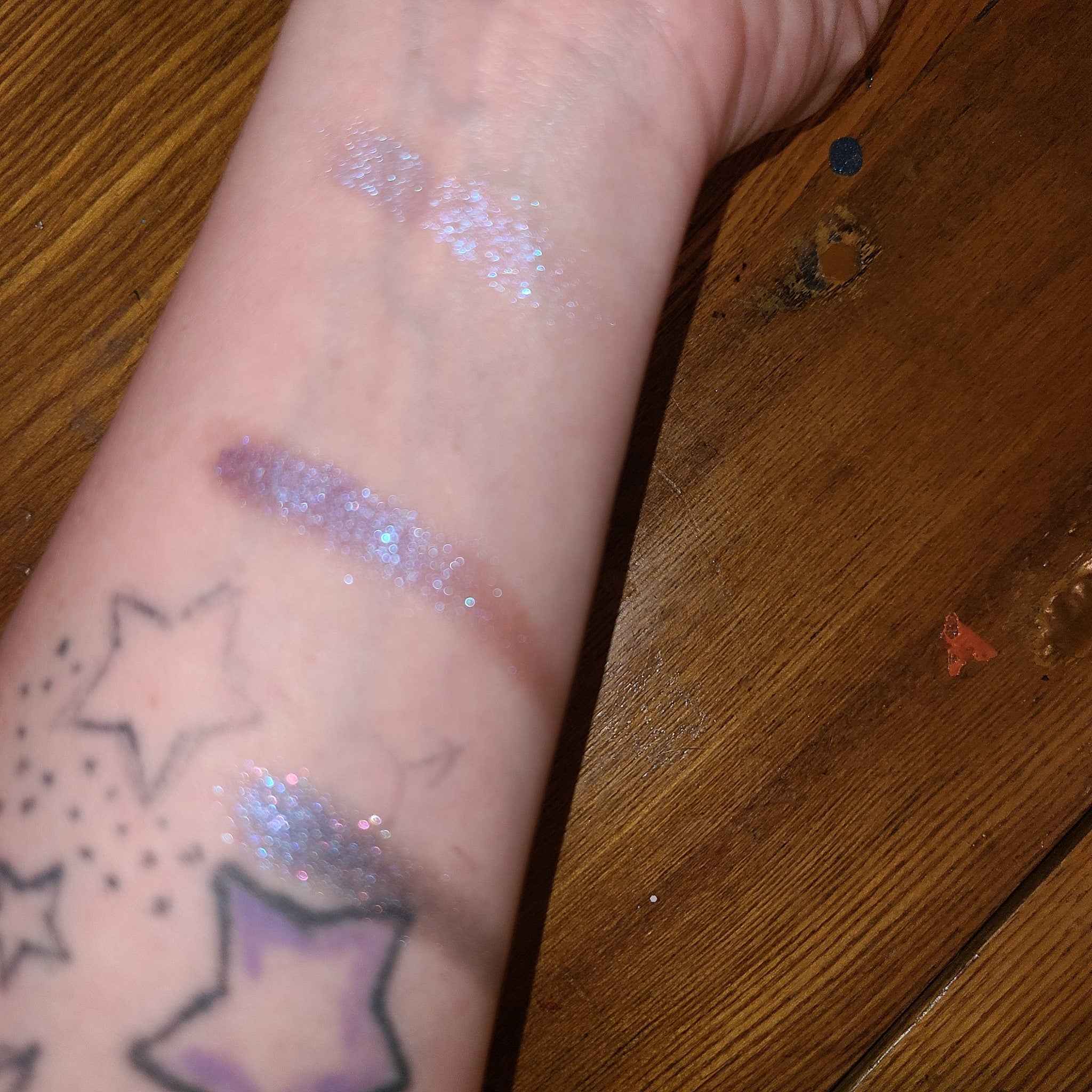 Close-up of two purple eye shadow pans showing bruised plum and soft lilac shades in matte finish