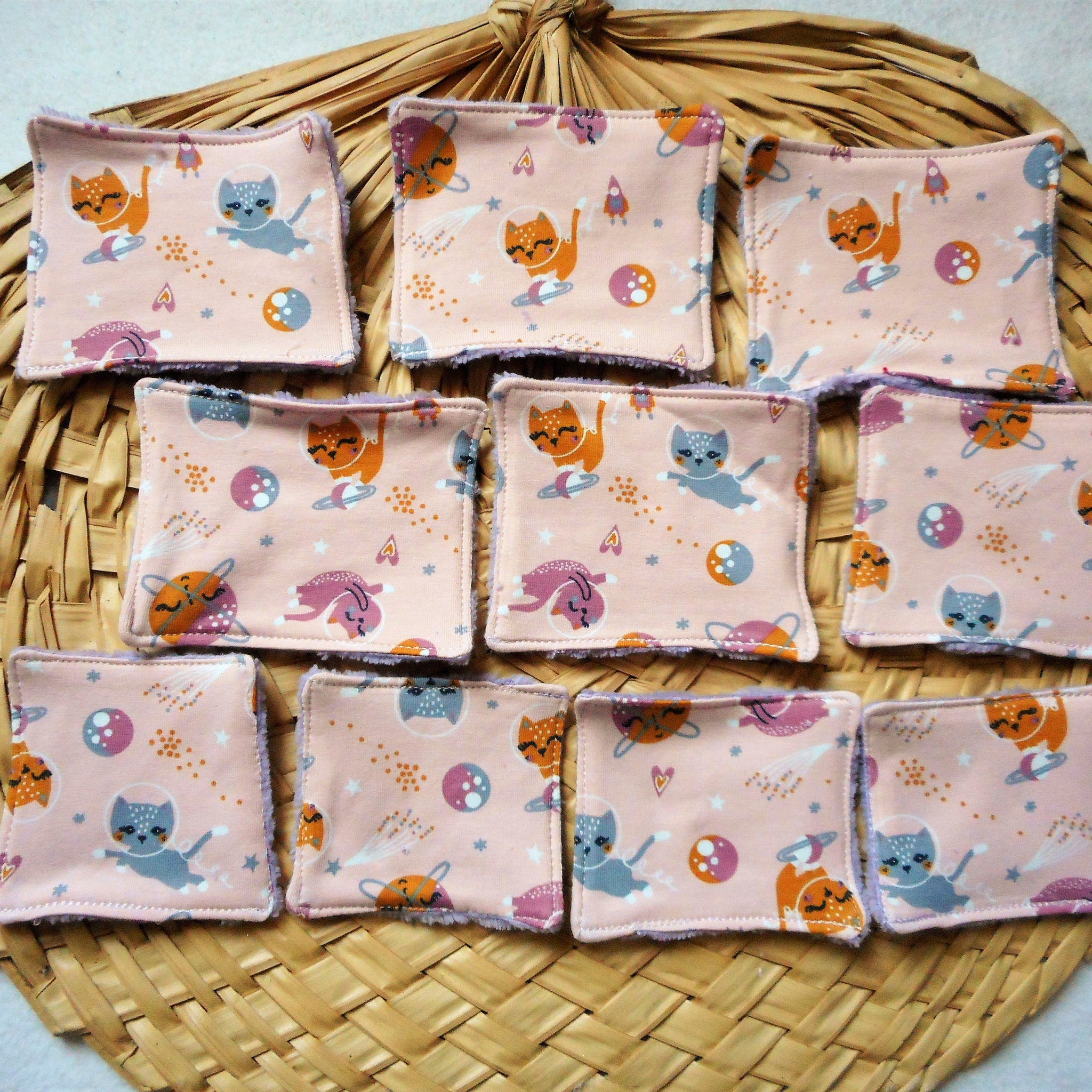 Reusable face pads with pink fabric, cat pattern, and purple trim.