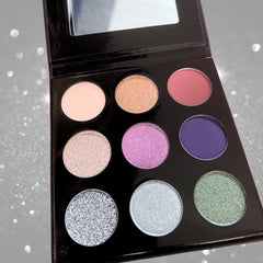 Eyeshadow palette with multiple colors, including glitter and matte finishes, in a black compact