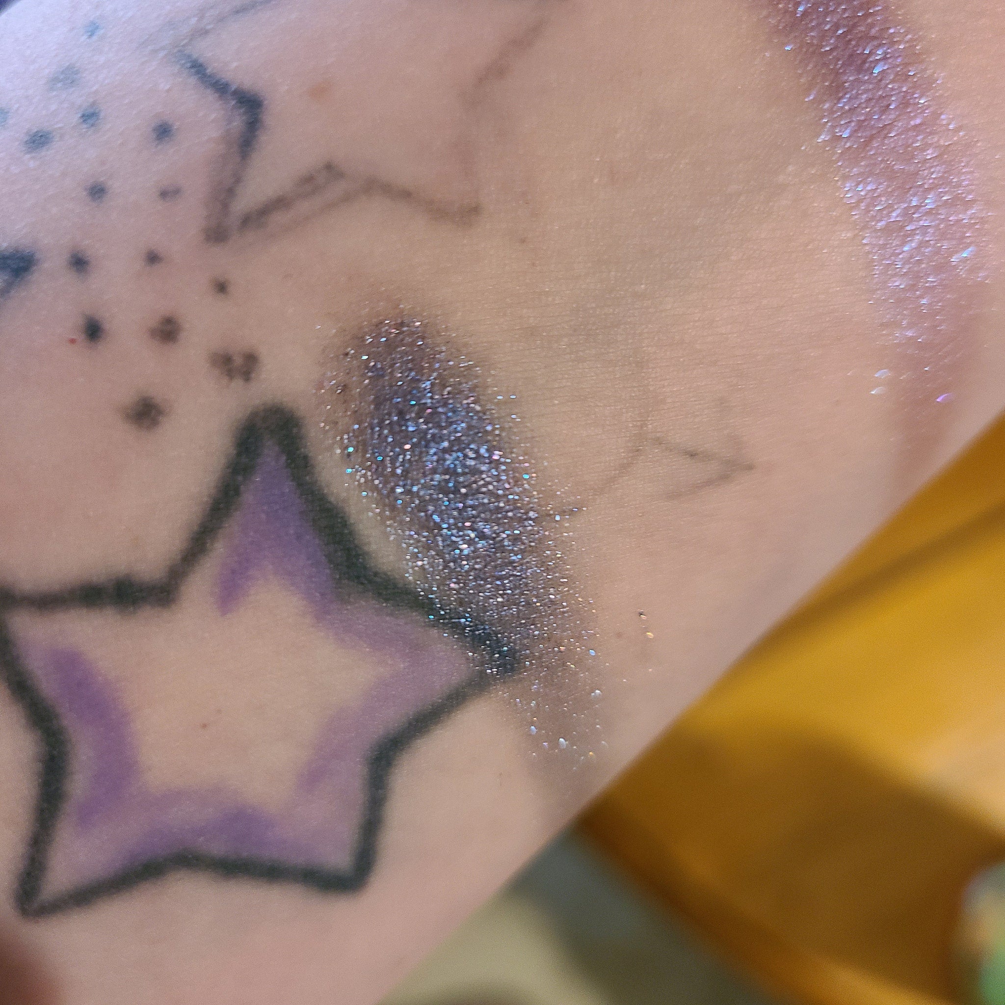 Close-up of two purple eyeshadow pans showing matte and shimmer textures in a compact palette