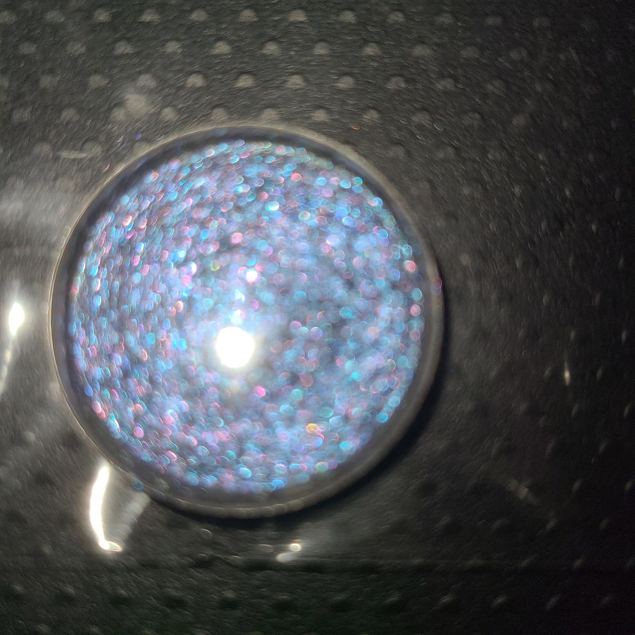 Side view of two purple eyeshadow pans showing satin and shimmer textures in compact palette